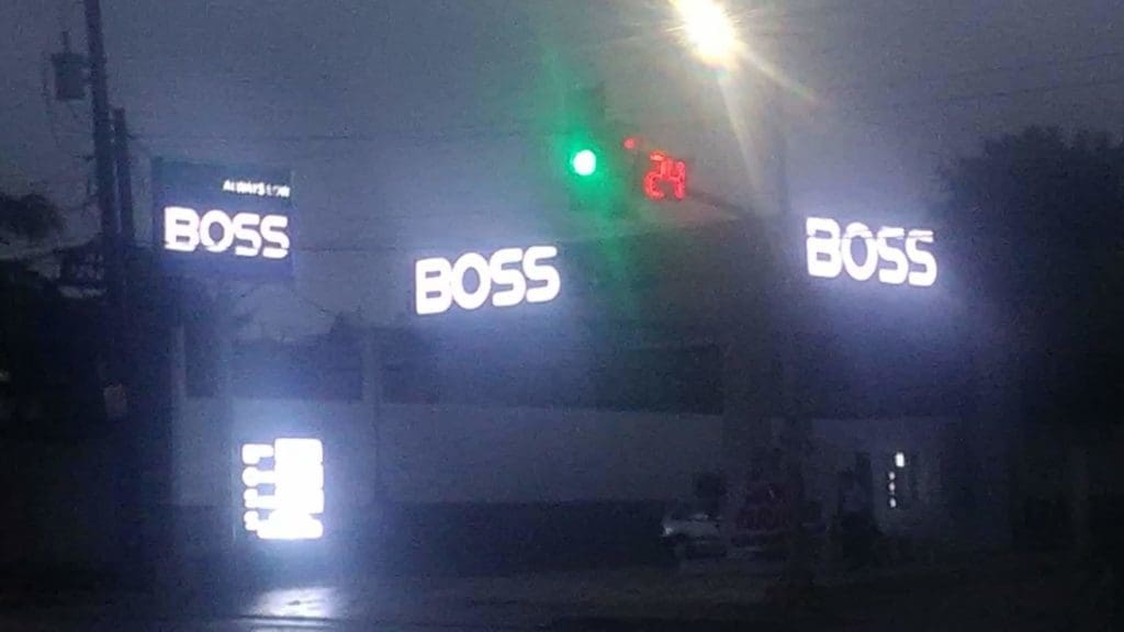 BOSS LED signage on building exterior at night in Makati, green traffic light, digital timer 24 seconds by M&G Global Ads.